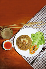 steamed rice food served on a plate with gravy, chili sauce, and lettuce
