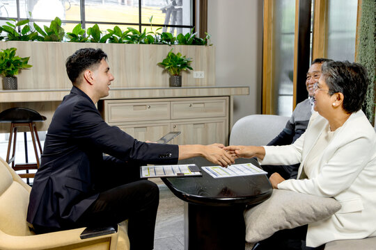 Financial advisor advising retirement advice to senior Asian couple. Happy mature couple discussing retirement planning with advisor. Elderly customers meeting with agent to sign insurance agreement.