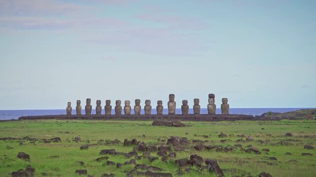 Moai statues stand in a row on easter island against a blue sky