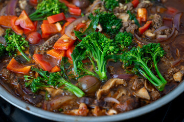 Close up of Healthy One Pot Meal of Ground Bison, Mushrooms, Broccoli, Barley, and Quinoa with Fresh Herbs