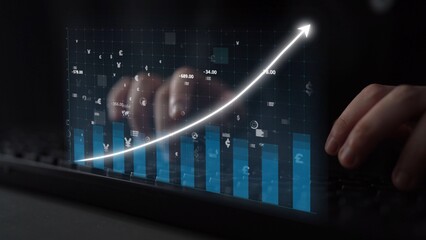 A close-up view of hands on a keyboard with a digital display showing stock market data, featuring a rising graph and currency symbols representing financial analysis. Copula