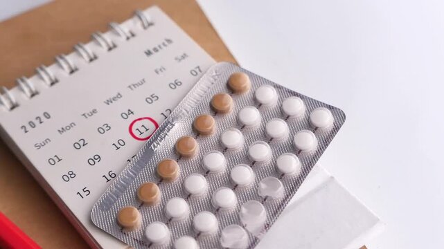 Close-up video of contraceptive pills placed on a calendar with a marked date, representing women&rsquo;s health, birth control, family planning, and reproductive healthcare.