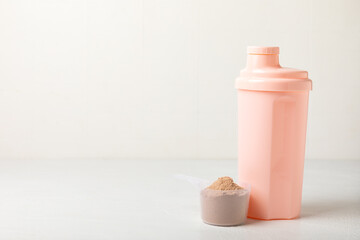 Protein shake with protein powder on a colored background. The powder is mixed with water or milk. A dietary supplement for a balanced diet. Whey protein. Fitness and gym diet nutrition.