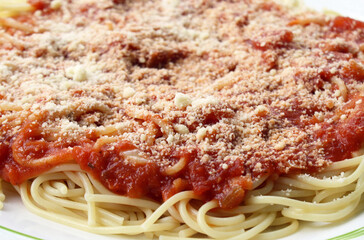 Cooked spaghetti noodles with homemade tomato sauce and grated parmesan cheese 