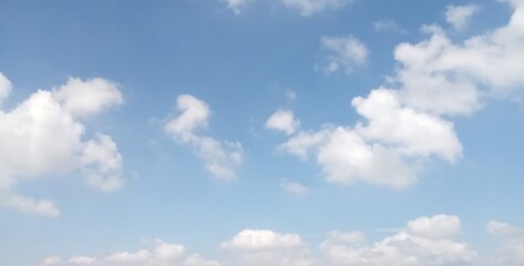 Beautiful blue sky with fluffy white clouds during bright sunny day