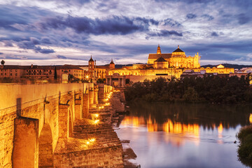 Illuminated Mezquita Cathedral and Roman Bridge in Cordoba at Sunset, Andalusia