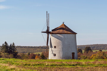 Rustic stone windmill in a grassy field