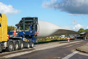 Naklejka premium Heavy transport truck carrying massive wind turbine blade for renewable energy construction project
