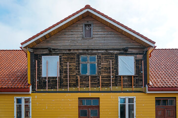 Historic wooden house renovation with new siding and insulation under reconstruction process
