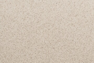 A close-up of a beige speckled stone surface. A neutral and modern texture for countertops, floors, and architectural design backgrounds.