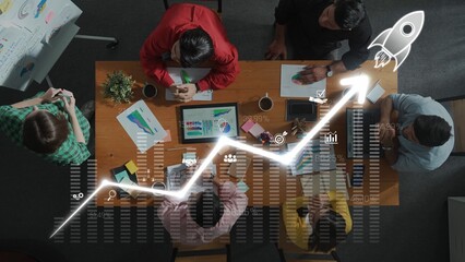 A dynamic team collaborates in a modern office, discussing growth strategies while analyzing data and creative ideas on a digital device. Raster