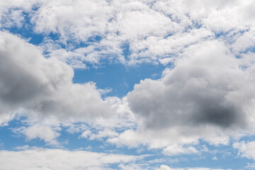 White and gray clouds in blue sky with shades of natural light in broad daylight