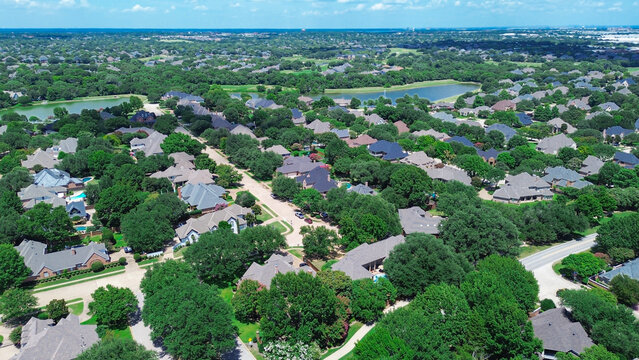 Dual scenic ponds with water fountain in upscale neighborhood in Colleyville, Texas, dense residential layout with tree-lined streets, landscaped yards, and large two-story homes, suburbs Dallas