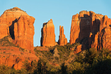 A close-up photo of Cathedral Rock Formation at sunset, illuminating the red rocks. Cathedral Rock is a popular landmark location in Sedona, Arizona, USA.

