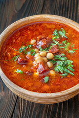 Rustic bowl of Spanish chorizo tomato chickpeas soup topped with cilantro