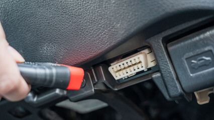 Woman using OBD2 diagnostic scanner.