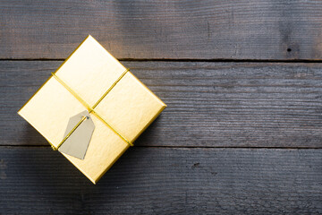 golden gift box on black wood background