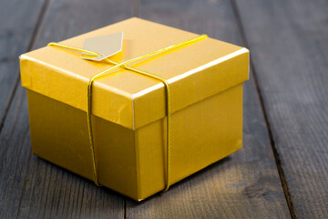 golden gift box on black wood background