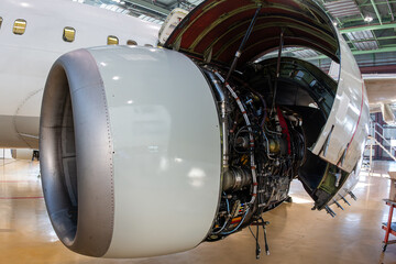 Close-up of an open high bypass turbofan aircraft engine of a passenger plane in aviation hangar