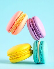Colorful macarons float mid-air on pastel blue background. Pink, yellow, purple, and turquoise cookies in soft light. Minimal, playful, elegant dessert display.