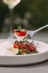 Tasting fresh caprese salad with cherry tomatoes
