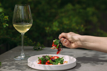 Enjoying fresh gourmet salad and white wine outdoors