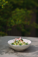 Healthy green salad with radishes on outdoor table
