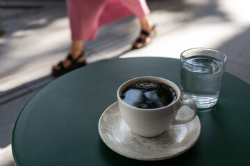 Morning coffee on a city street table. Scene reflects the concept of urban lifestyle, daily routine, and small moments of relaxation in a fast-moving environment.