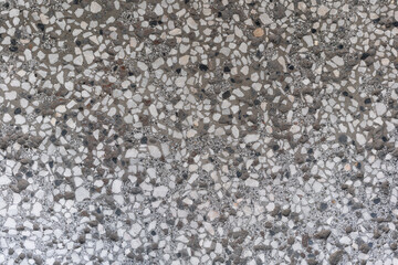 Concrete terrazzo surface with stone fragments and mixed mineral texture. This photo describes the concept of construction, architecture, material, durability, and urban design.