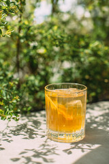 Refreshing iced drink with lemon garnish and green background