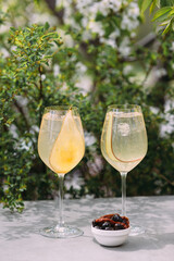 Two refreshing pear prosecco cocktails with olives and crackers