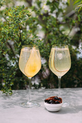 Refreshing pear cocktails with snacks on an outdoor table