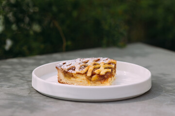 Slice of apple pie with lattice crust powdered