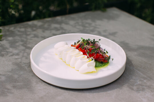 Caprese salad with mozzarella, tomatoes and microgreens