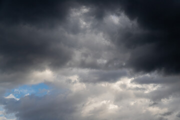 Dramatic Stormy Clouds Over Blue Sky With Light Breaks and Darkened Horizon