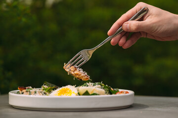 Hand holding fork with salad for healthy eating
