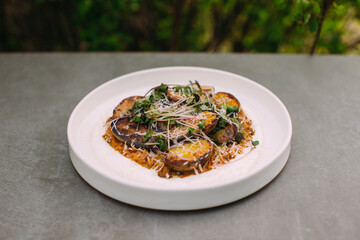 Roasted potatoes with herbs and grated cheese on plate