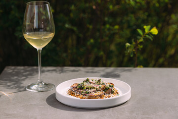 Plated food on table with wine glass outdoors