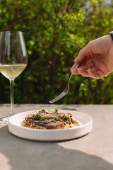 Tasting gourmet dish with wine at outdoor restaurant