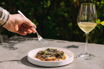 Man's hand holding fork eating vegetarian meal