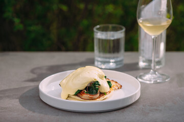 Gourmet breakfast dish with hollandaise, spinach and shrimp