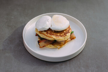 Savory pancakes with crispy bacon and poached eggs