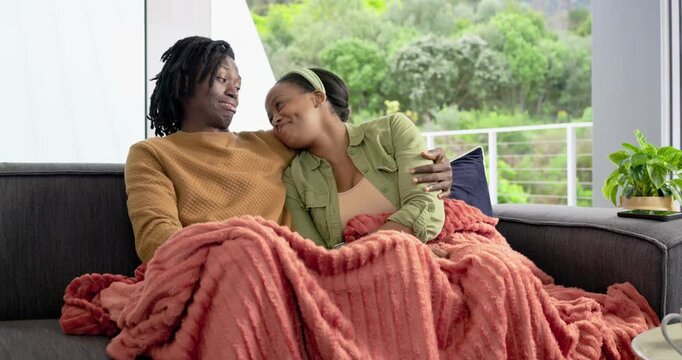 After woman crying, African American couple cuddling at home, wiping tears, gazing through window