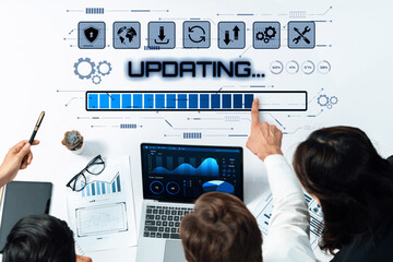 A diverse team engages in data analysis, collaborating over a laptop that displays dynamic charts while they update information on a digital interface. Trope