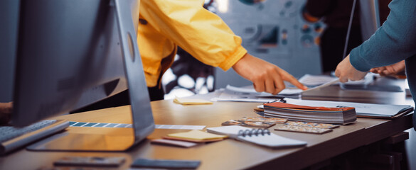 A collaborative workspace showcasing designers discussing and sharing ideas with technology and project materials on a modern office table, emphasizing creativity and teamwork. SACTR