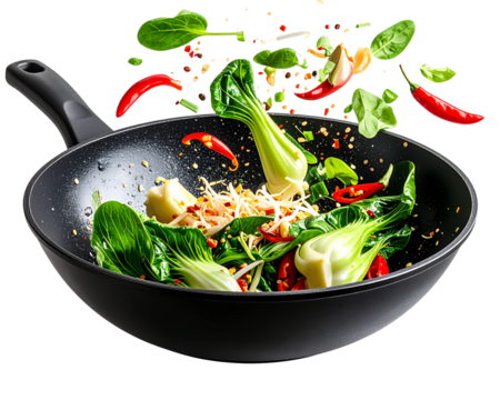 A black wok-style frying pan tossing vegetables upward in mid-air, including bok choy 