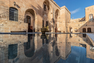 Courtyard of Reji Kilisesi church mirroring in a fountain in the old town of Sanliurfa, Turkey