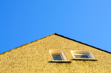 Part of triangular roof against clear blue sky in daylight