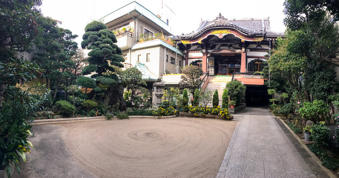 Templo japon&eacute;s tradicional con tejado curvo y jard&iacute;n cuidado, &aacute;rboles podados y zona de arena rastrillada estilo zen. Escena serena de arquitectura y paisajismo japon&eacute;s.