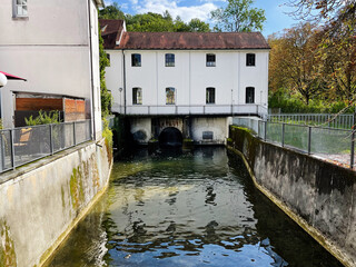 Canal side building over water in Furstenfeldbruck Germany with arches and white facade